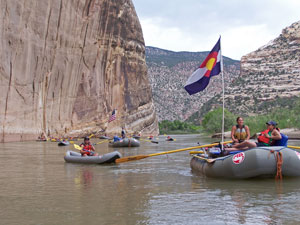 Rafts and inflatable kayaks floating by Steamboat Rock at the confluence of the Yampa and Green Rivers.